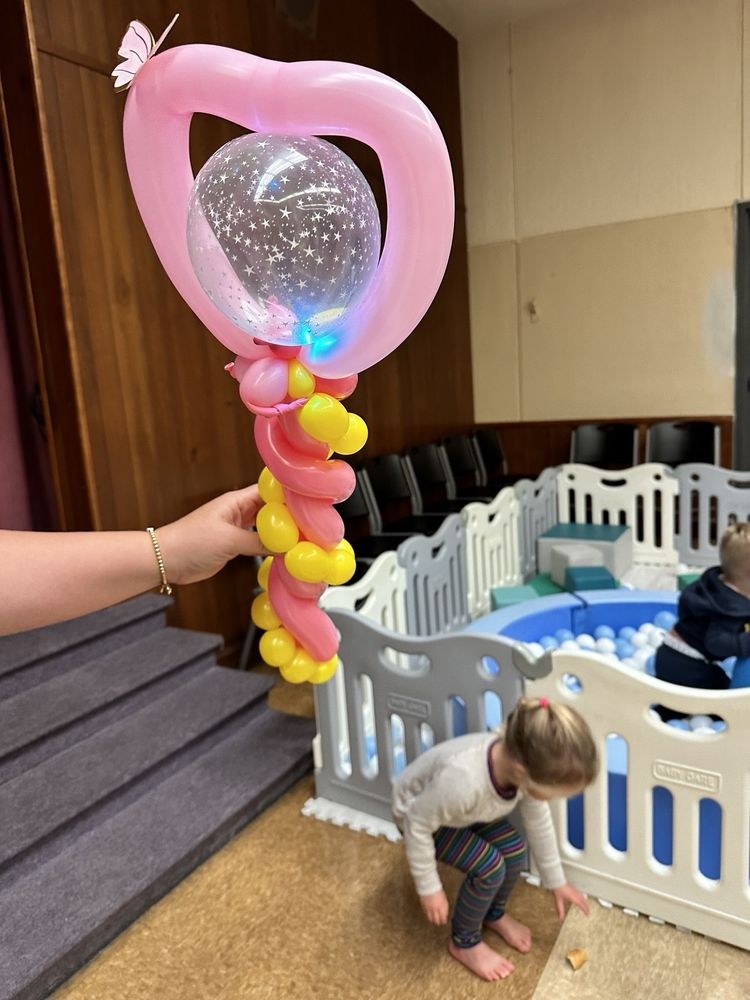 Heart Balloon Sculpture Pink heart-shaped balloon sculpture held above a party play area
