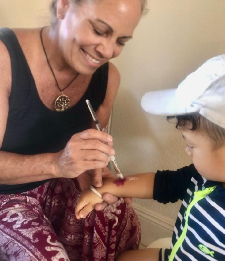 Artist painting a child's arm during a party