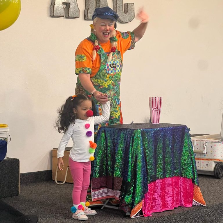 Sparkles performing a playful magic routine with a child volunteer