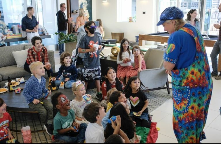Sparkles entertaining a seated group of children during a party performance